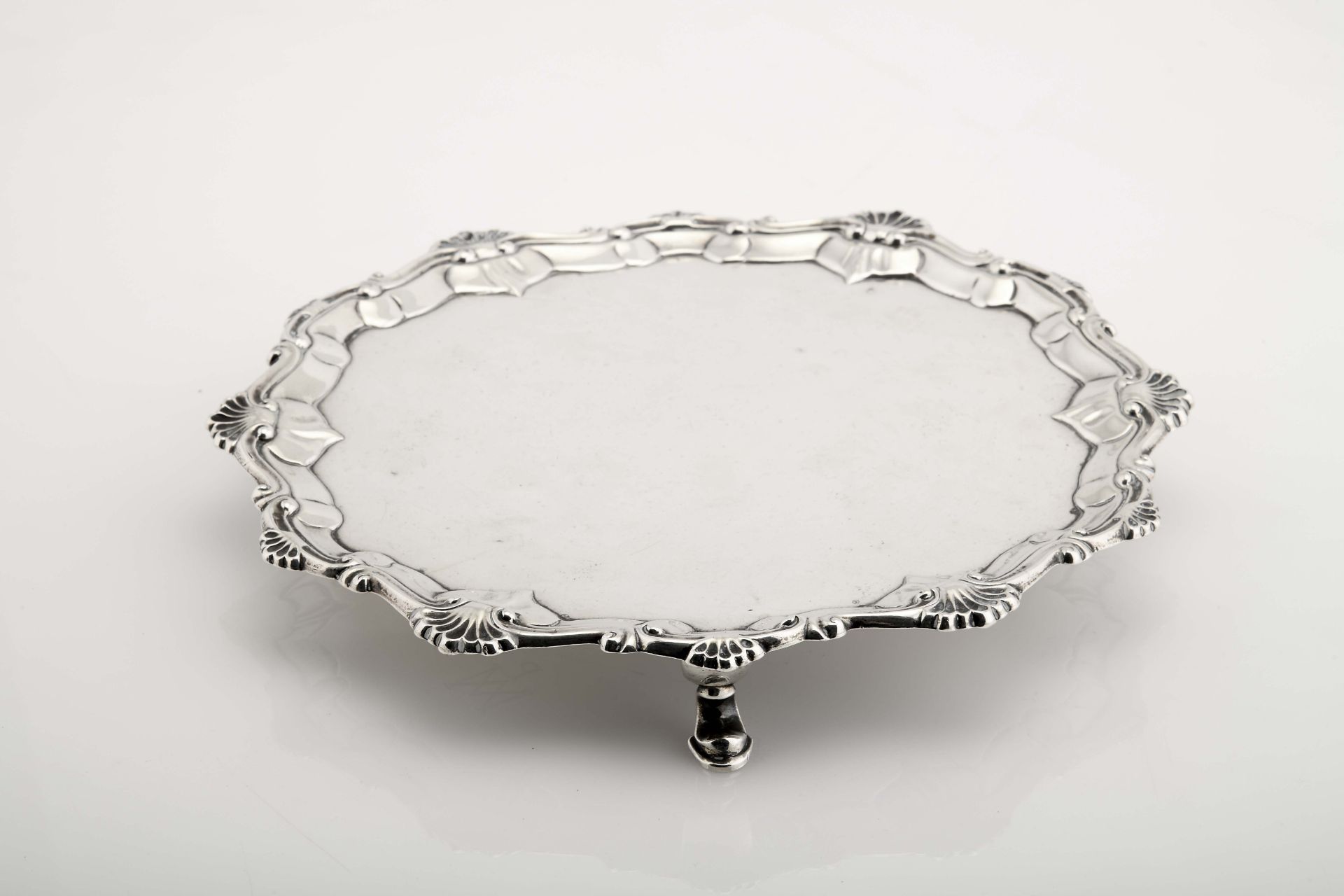 A scalloped three-footed salver