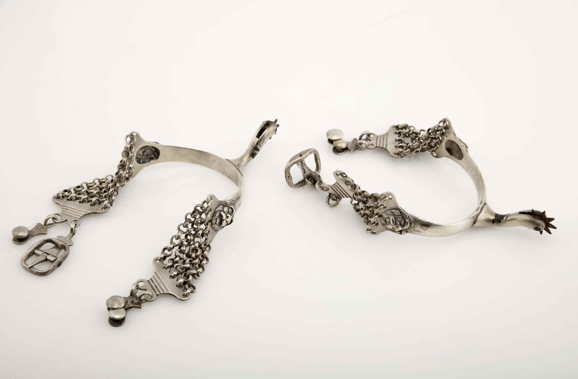 A pair of spurs with chains