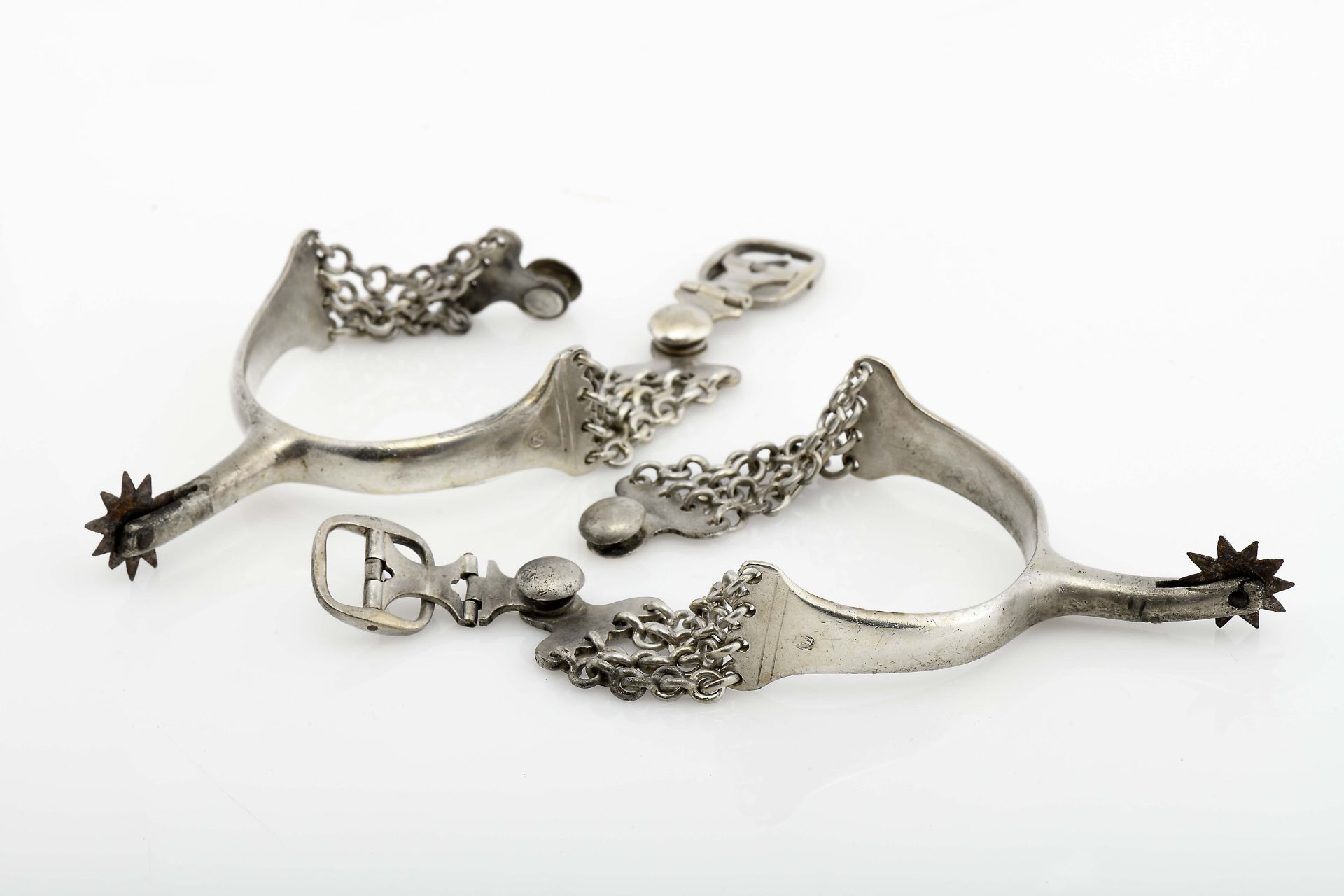 A pair of spurs with chains