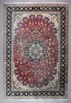 A 20th Century Tabriz Carpet woven in colours of ivory, navy blue and wine, with a central