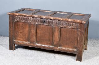 An 18th Century Panelled Oak Coffer, with moulded edge and four fielded panels to top, carved and