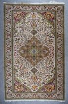 A 20th Century Keysari Carpet woven in colours of fawn, ivory and green, with a central stylised