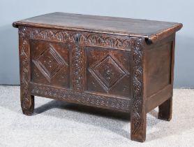 A Late 17th Century Carved Oak Coffer, with three plank cleated top, the frieze carved with stylised