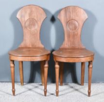 A Pair of George III Mahogany Hall Chairs, the shaped backs with moulded edges, matching wood