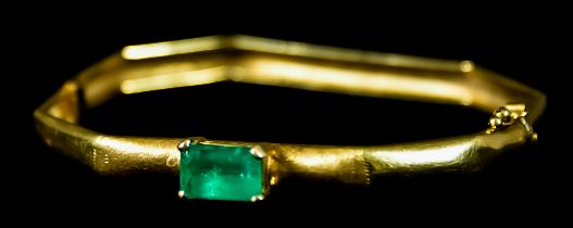 An 18ct Gold and Emerald Bangle, set with a single emerald stone, approximately 2ct, 60mm x 50mm,