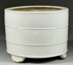 A Chinese Celadon Porcelain Brush Pot with an incised running leaf motif, on three feet, impressed