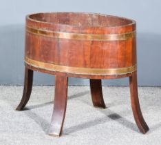 A Mahogany and Brass Bound Oval Wine Cooler, on splayed legs, 28ins wide x 24ins high