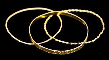 Three Yellow Metal Stiff Bangles, gross weight 27.2g Note:Metal unmarked but tests as 18ct gold