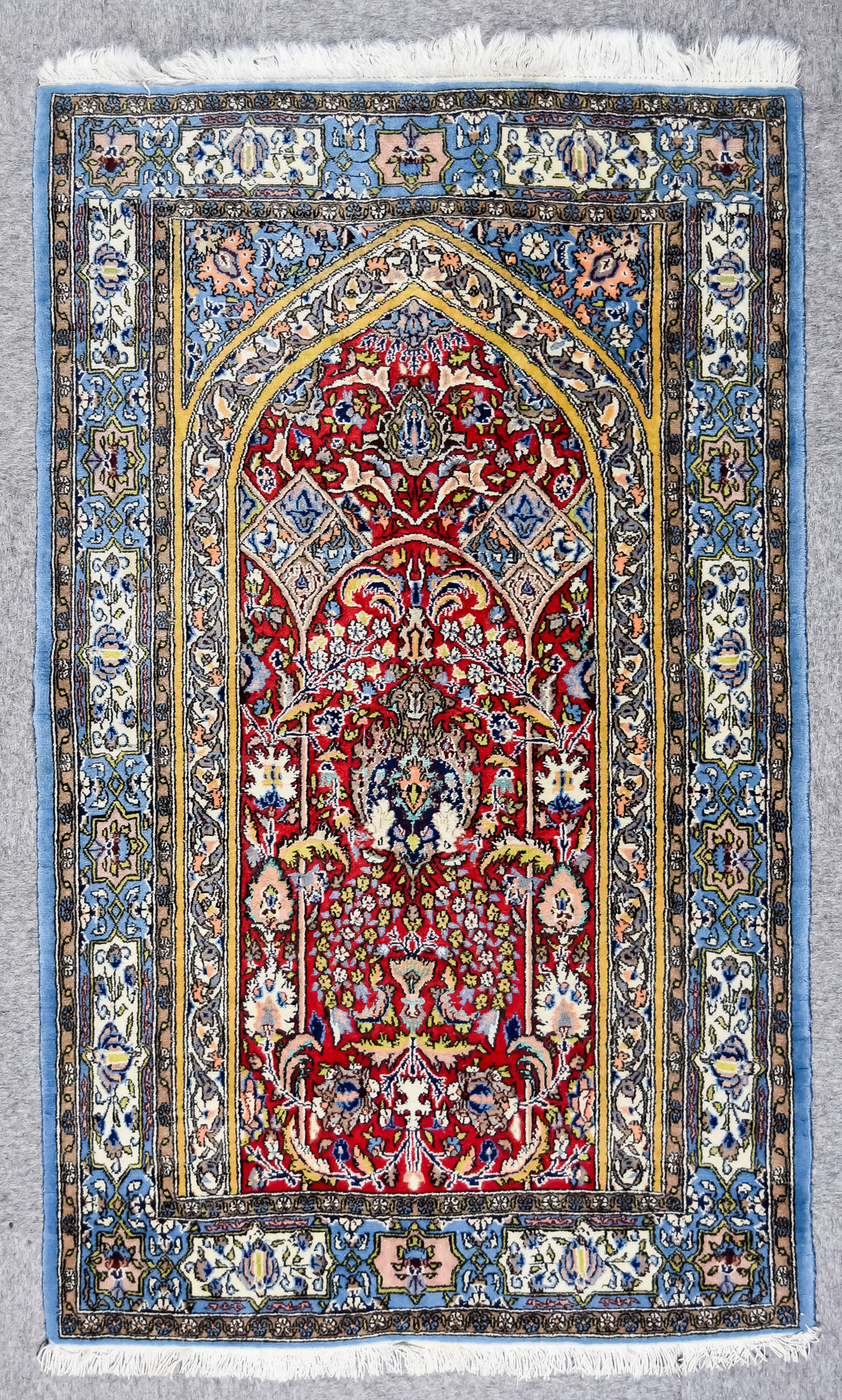 A Fine Isfahan Prayer Rug, Mid-20th Century, woven in colours of wine, ivory and blue, with a