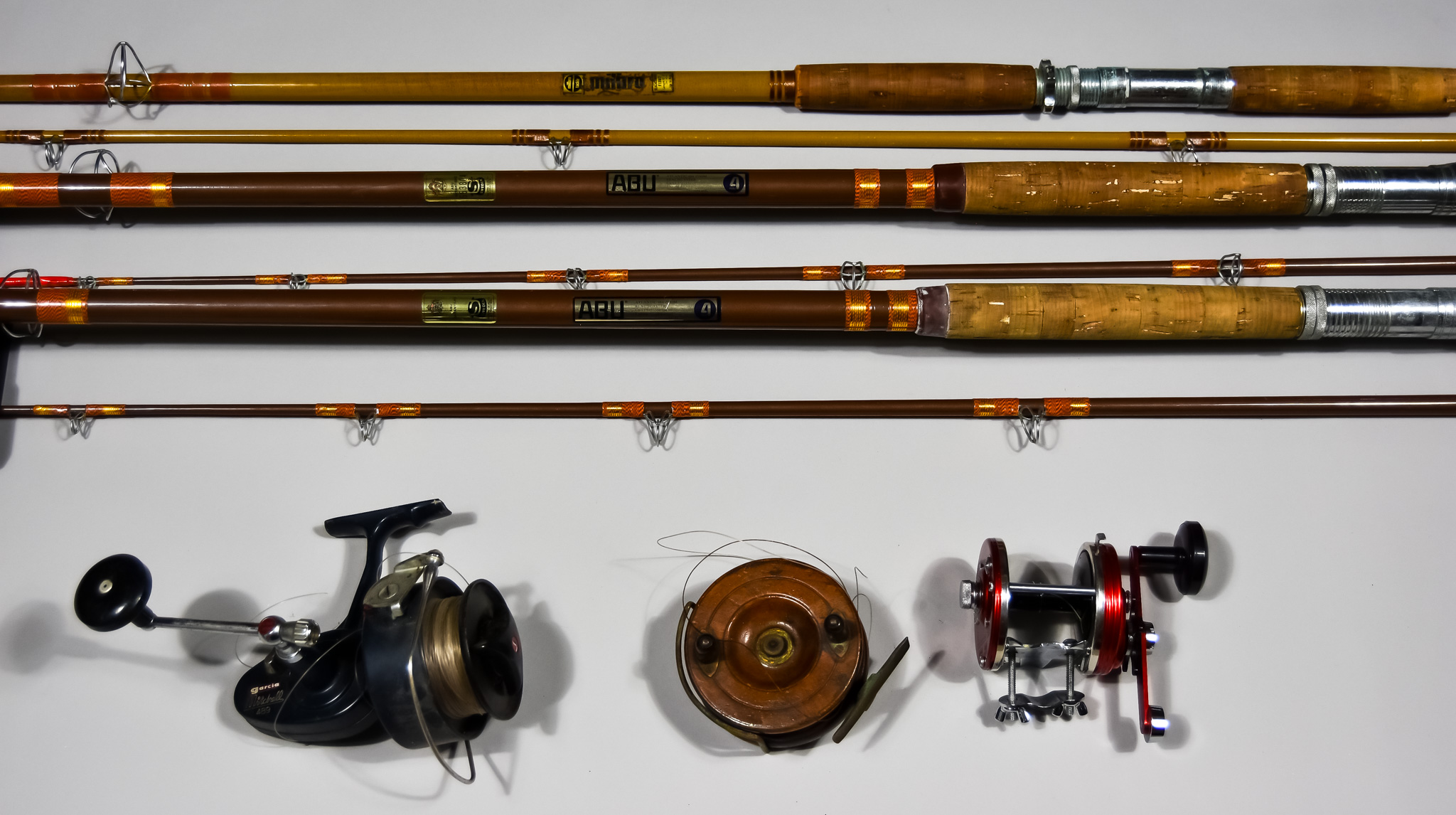 A Small Collection of Fishing Related Material, including eight rods, six reels, some by Abu and