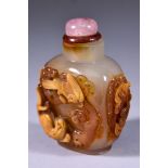 A Chinese Agate Snuff Bottle, carved in relief with bird perched on branch looking down at lion to