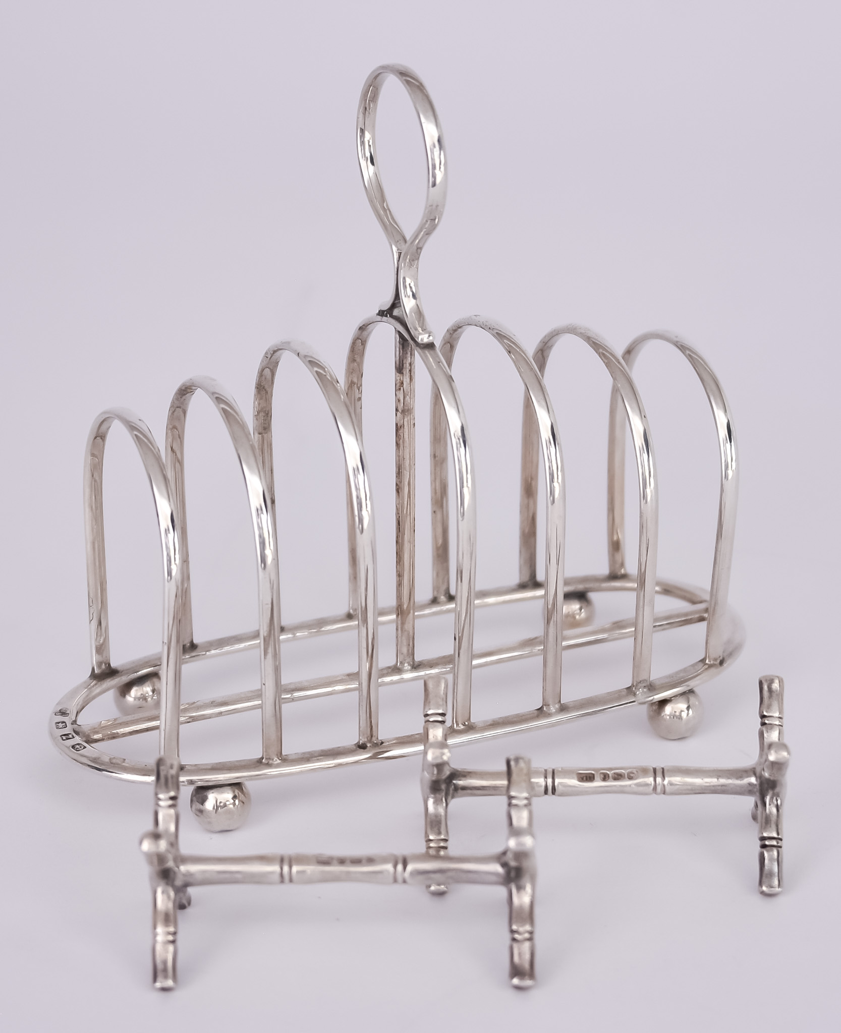 A Late Victorian Silver Six-Division Toast Rack and a Pair of Knife Rests, the toast rack by