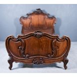 A Late 19th Century French Oak 5ft Bedstead, the head and foot board with leaf carved and scroll