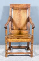 An Old Panelled Oak Armchair, with plain crest rail, raised panel to back, wood seat, on turned