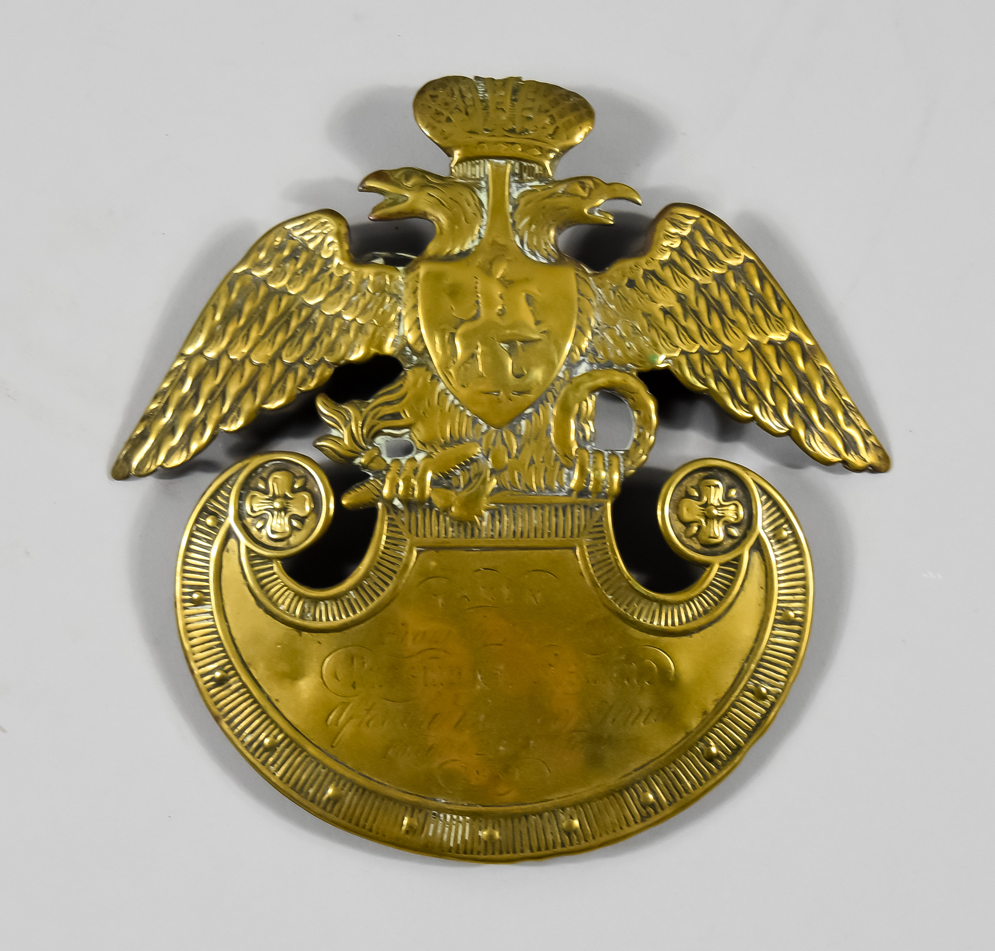 A Russian Pressed Brass Shako Plate, Mid 19th Century, with double-headed eagle, engraved "Taken