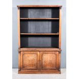 An Early Victorian Mahogany Bookcase, the upper part with shaped cresting, fitted two open