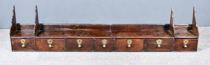 An 18th Century Oak Wall Mounted Set of Drawers with open shelf, fitted seven drawers, 75.5ins