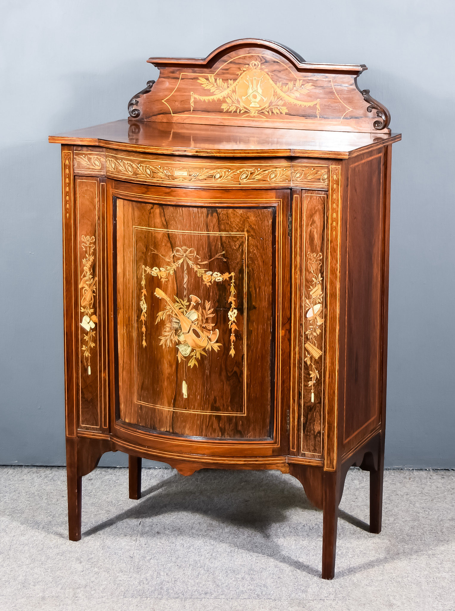 An Edwardian Mahogany and Inlaid Bow Front Music Cabinet by Maple & Co., London and Paris, the whole