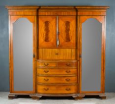 An Edwardian Satinwood and Inlaid Breakfront Wardrobe, with moulded cornice, fitted with three