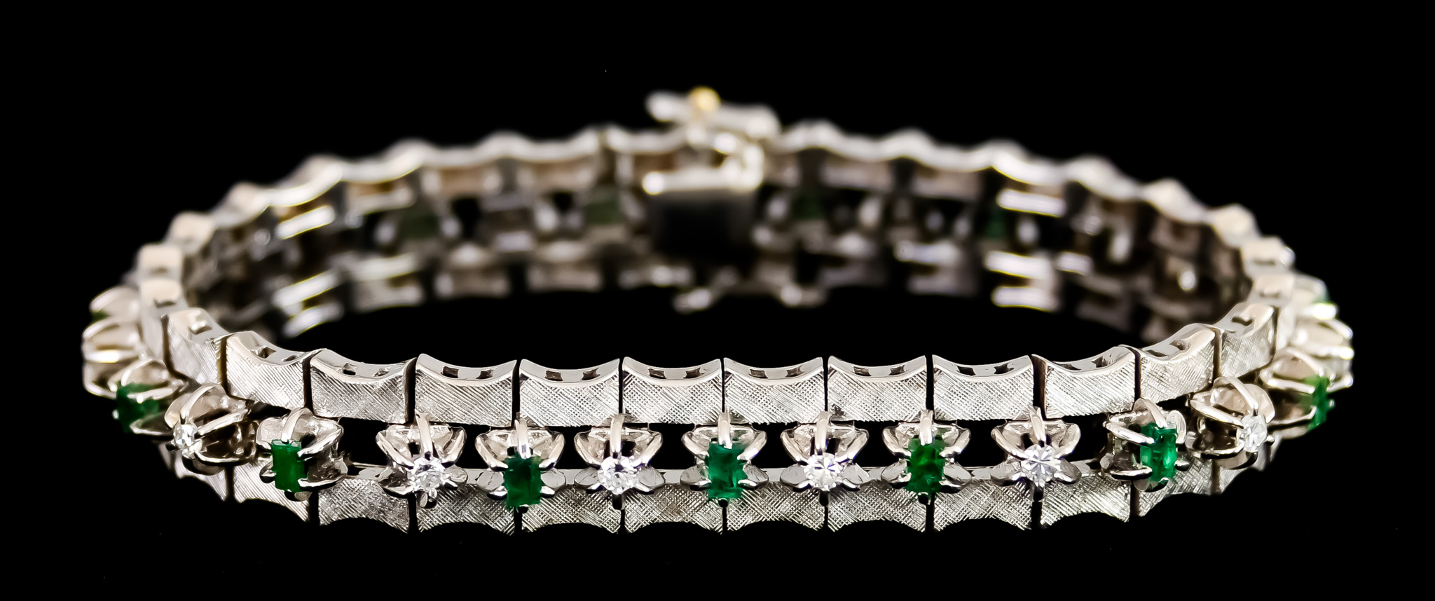 An 18ct White Gold Bracelet, set with small diamond and emerald stones, 190mm overall, gross