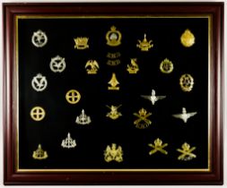 A Framed Collection of British Military Cap Badges, various regiments and arms, 26 in total Note: