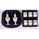 A Set of Six Edward VII Silver Napkin Rings and a Pair of Pepper Pots, the napkin rings by
