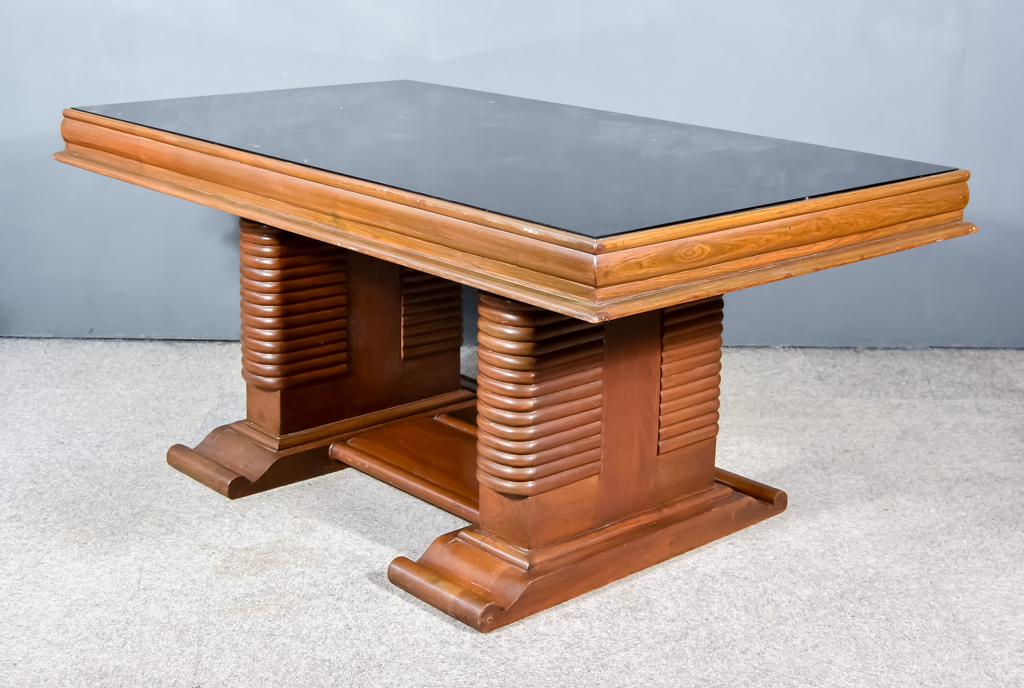 An Early 20th Century Stained Walnut Table of Art Deco Design, with black smokey glass inset and