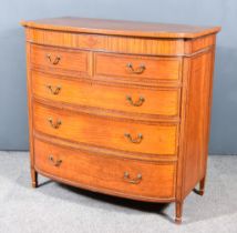 An Edwardian Satinwood and Inlaid Bow and Breakfront Chest with cross banding to top, fitted two