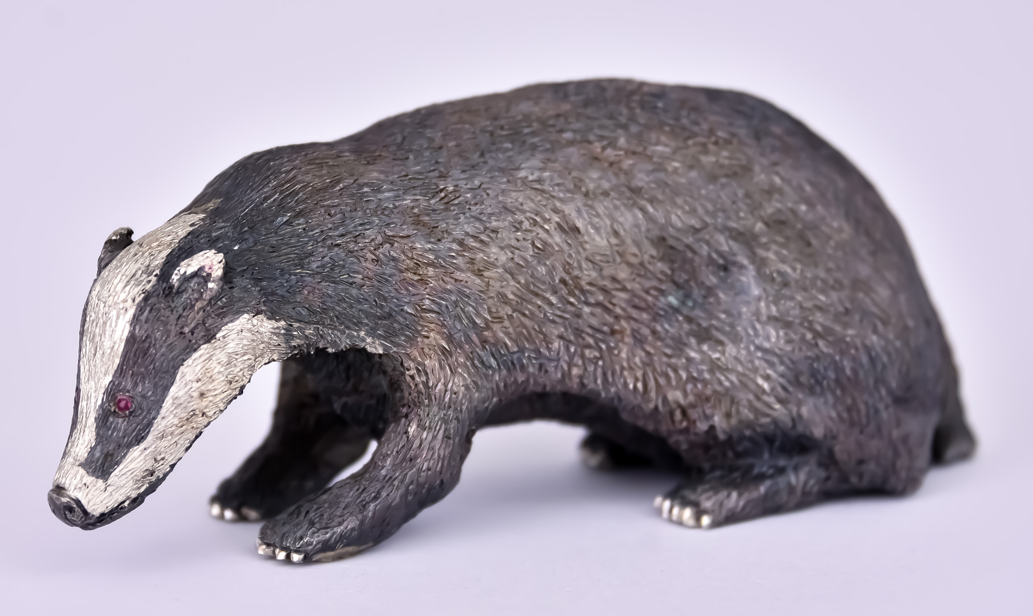 An Elizabeth II Silver Cast Figure of a Badger, by GL, London 1991, 4ins overall x 1.5ins high,