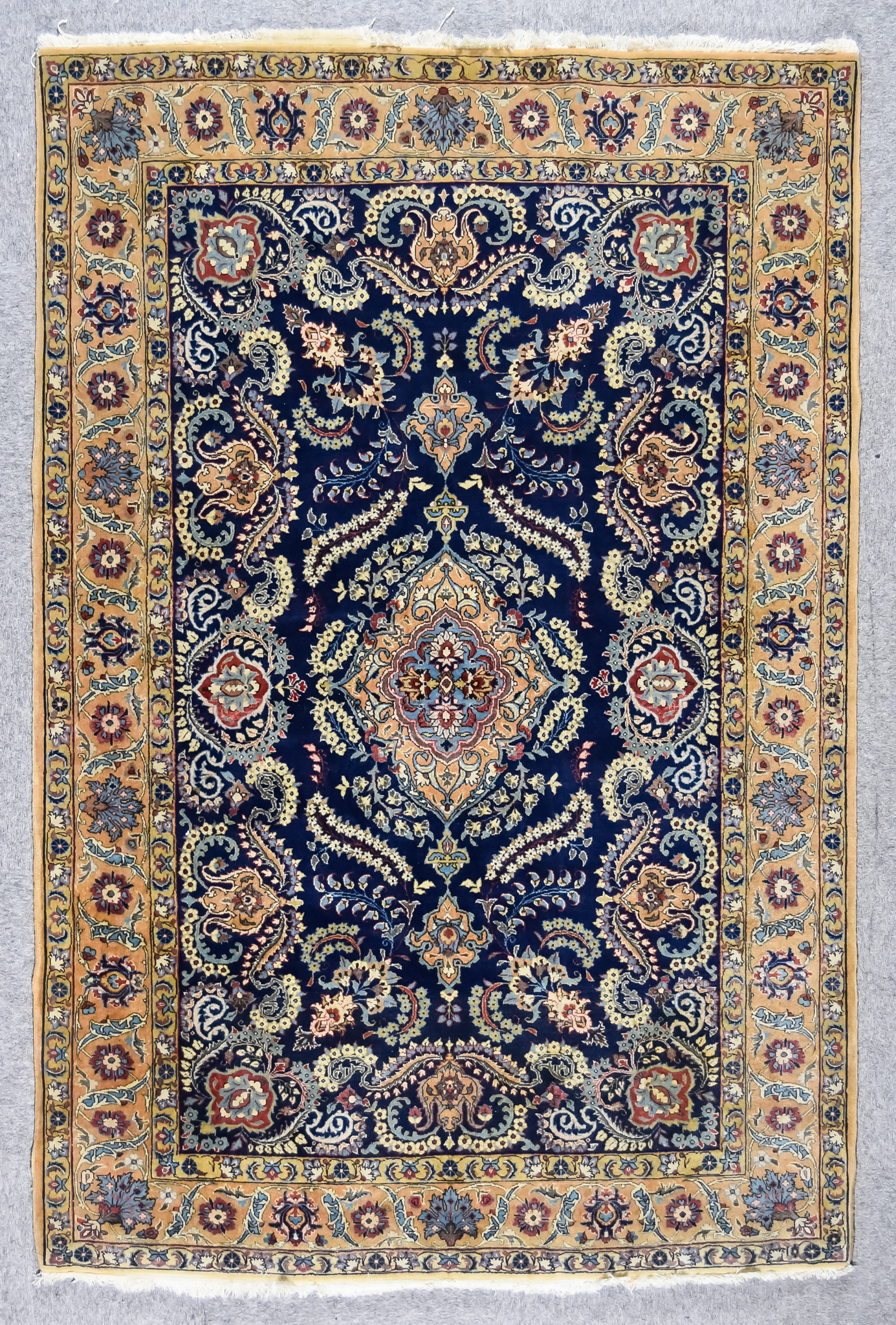 A 20th Century Ghom Rug woven in muted shades, with a central stylised floral medallion flanked by