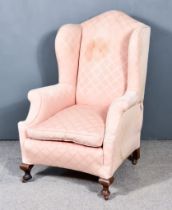 A Late 19th Century Wing Back Armchair of "Georgian Design", with shaped back, out scrolled arms,