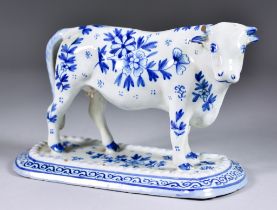 A Delft Standing Model of a Cow, 20th Century, painted in blue with scattered flower and leaf