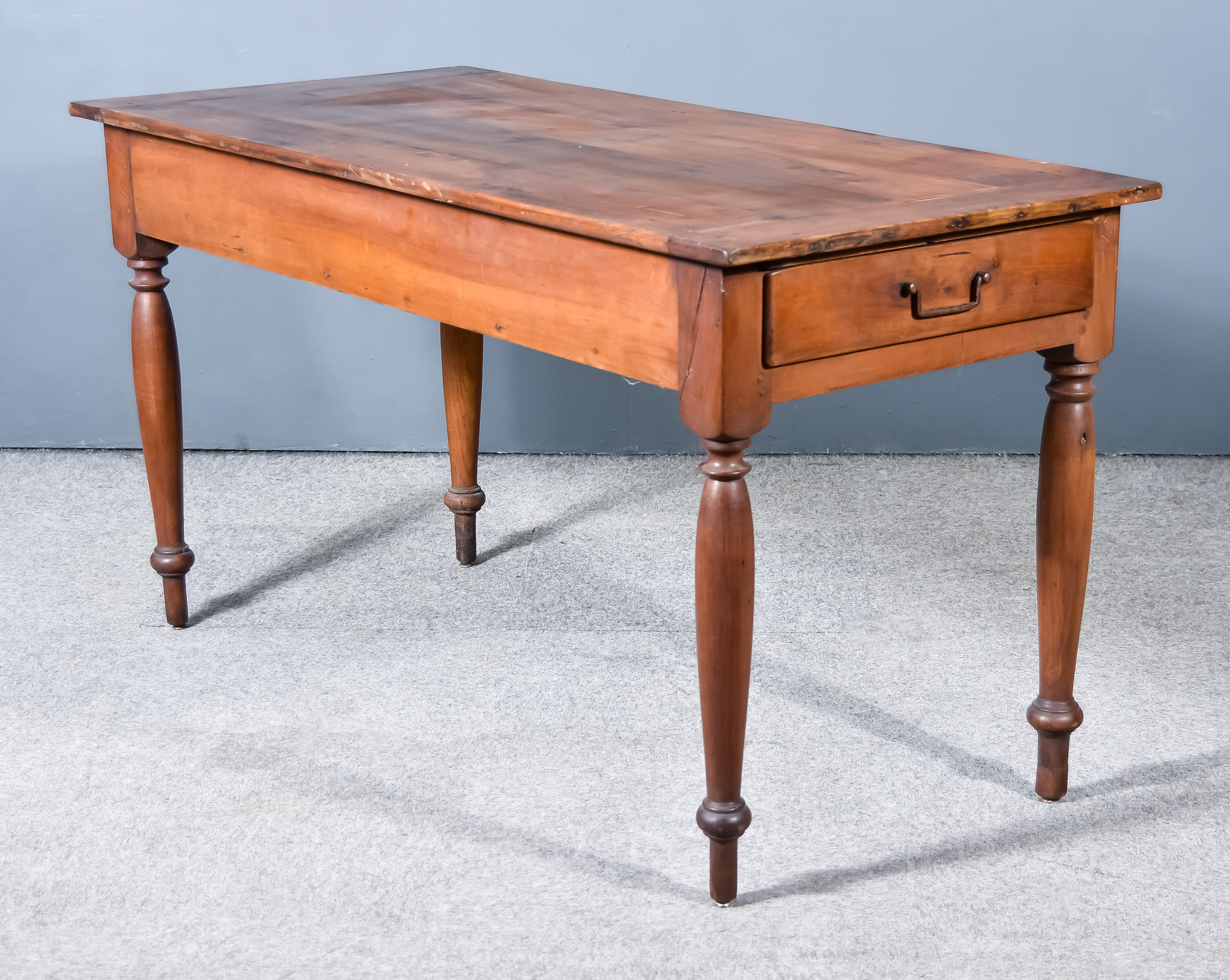 A 19th Century French Provincial Fruit Wood Kitchen Table, with four plank cleated top, fitted two