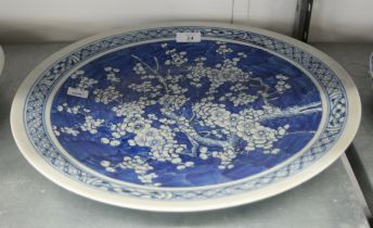 JAPANESE LATE MEIJI PERIOD PORCELAIN WALL PLAQUE painted in underglaze blue with PRUNUS BLOSSOM in