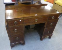 AN EDWARDIAN MAHOGANY KNEEHOLE DESK/DRESSING TABLE, HAVING 7 DRAWERS WITH DROP-RING HANDLES ON