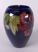 MOORCROFT POTTERY OVULAR VASE with tube-lined decoration of three large flowers and foliage, on a
