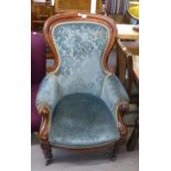 A VICTORIAN MAHOGANY FRAMED LADY'S SPOON-BACK FIRESIDE ARMCHAIR, UPHOLSTERED IN FLORAL TEAL FABRIC