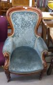 A VICTORIAN MAHOGANY FRAMED LADY'S SPOON-BACK FIRESIDE ARMCHAIR, UPHOLSTERED IN FLORAL TEAL FABRIC