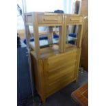 A LIGHT OAK BEDROOM SUITE OF THREE PIECES, VIZ A CHEST OF FIVE LONG DRAWERS, A PAIR OF BEDSIDE
