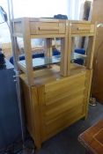 A LIGHT OAK BEDROOM SUITE OF THREE PIECES, VIZ A CHEST OF FIVE LONG DRAWERS, A PAIR OF BEDSIDE