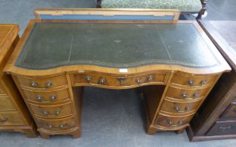 A REPRODUCTION WALNUT TWIN PEDESTAL DESK, WITH SERPENTINE SHAPED TOP AND GREEN LEATHER INSET