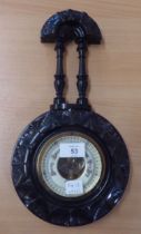 AN EBONISED ANEROID BAROMETER