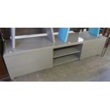 A LONG LOW HIGH GLOSS GREY TV UNIT, HAVING OPEN CENTRAL SECTION, FLANKED BY TWO DRAWERS TO EACH SIDE