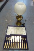 A BRASS OIL LAMP PATTERN ELECTRIC TABLE LAMP AND A CASED SET OF SIX PAIRS OF ELECTROPLATE FISH