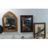 A PINE GOTHIC SHAPED WALL MIRROR TOGETHER WITH A RECTANGULAR DARK FRAMED WALL MIRROR AND A FRAMED