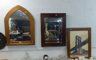 A PINE GOTHIC SHAPED WALL MIRROR TOGETHER WITH A RECTANGULAR DARK FRAMED WALL MIRROR AND A FRAMED