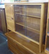 A BLOND WALNUT BOOKCASE WITH TWO GLASS SLIDING DOORS AND END CUPBOARD