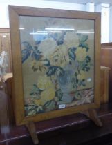 A LIGHT OAK FRAMED CHEVAL GRATESCREEN, WITH GLAZED AND FLORAL TAPESTRY PANEL, TWO LEATHER POUFFE'