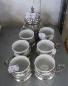 A SET OF SIX ELECTROPLATE COFFEE CUPS AND SAUCERS WITH FLORAL DECORATED CHINA LINERS AND A SUCRIER