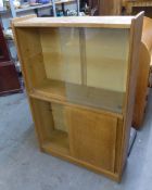 A LIGHT OAK BOOKCASE AND GLASS SLIDING DOORS AND CUPBOARD